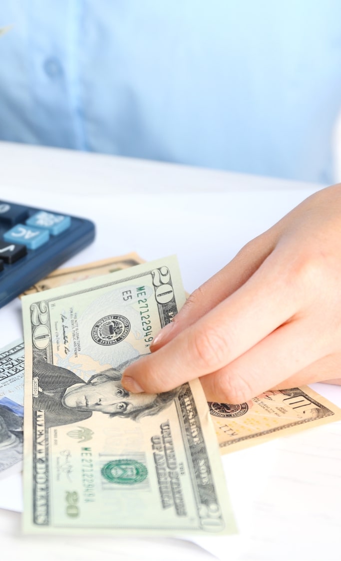 woman calculating and handing dollars