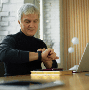 Older veteran at laptop checking watch